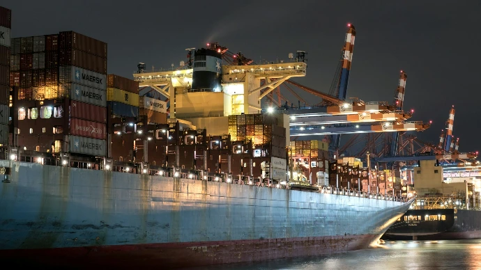 A large cargo ship in a harbor at night
